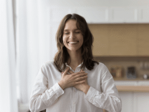 woman holding hands over chest smiling with gratitude